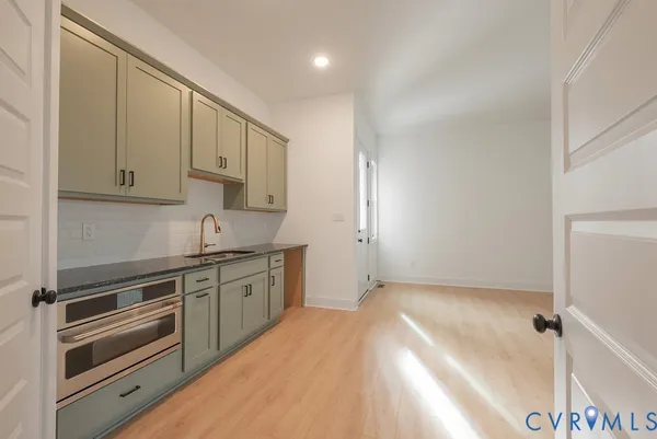 a kitchen with granite countertop white cabinets and white appliances