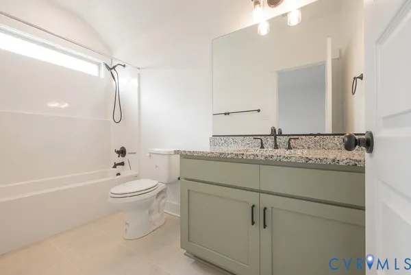 a bathroom with a granite countertop sink a toilet and shower