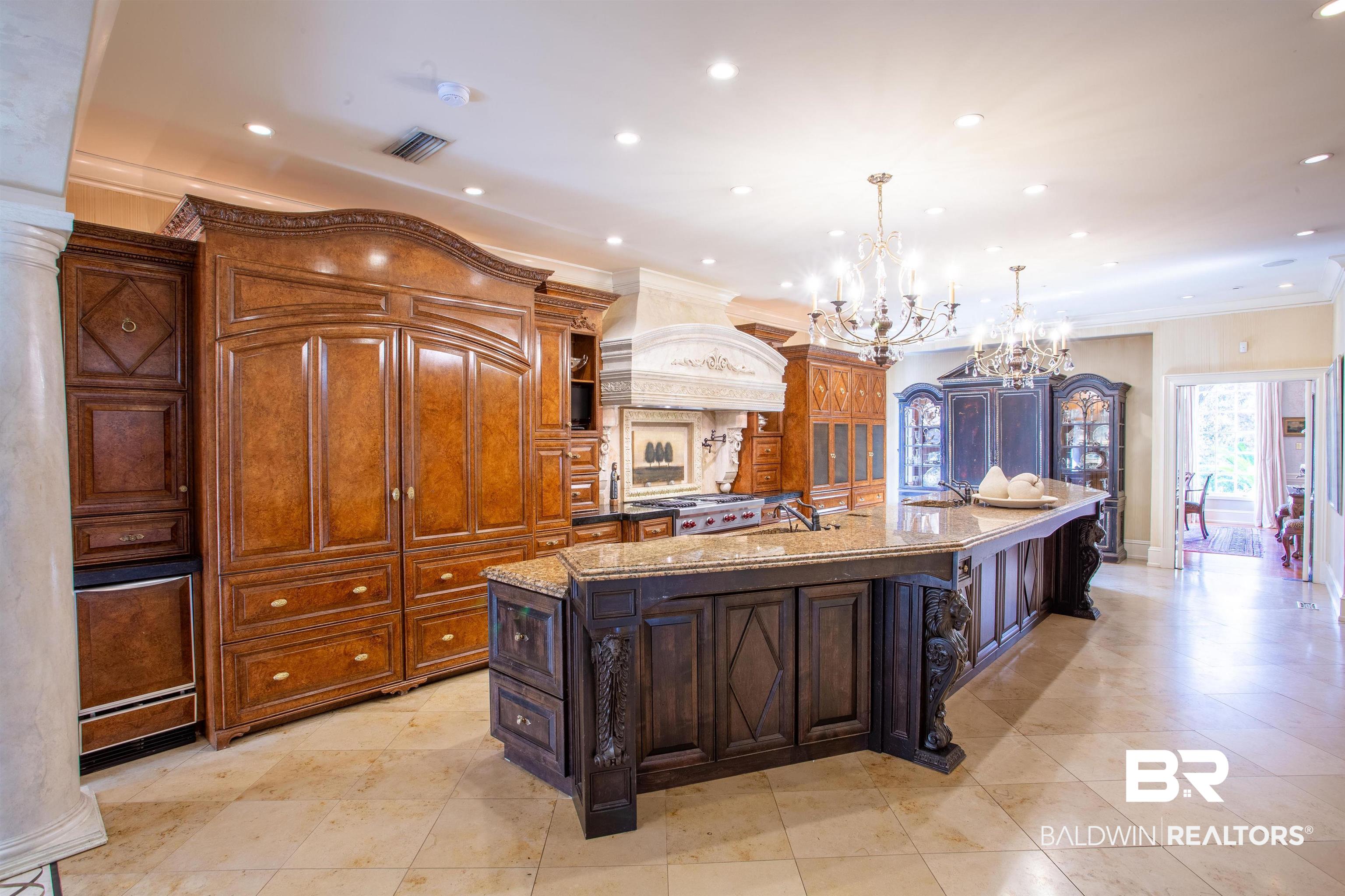 150 Austill Avenue Mobile, AL 36608 - Photo 22 of 39 Gourmet kitchen featuring a large central island with a granite countertop, custom wood cabinetry, integrated appliances, decorative range hood, and recessed lighting