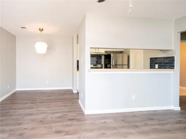 a view of a kitchen with wooden floor and a window