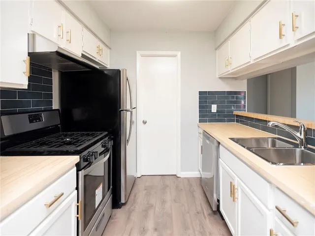 a kitchen with granite countertop a sink and a stove top oven