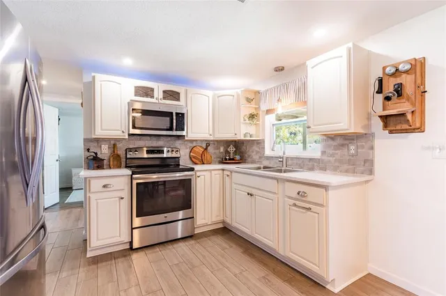 a kitchen with stainless steel appliances granite countertop a stove a sink and a refrigerator