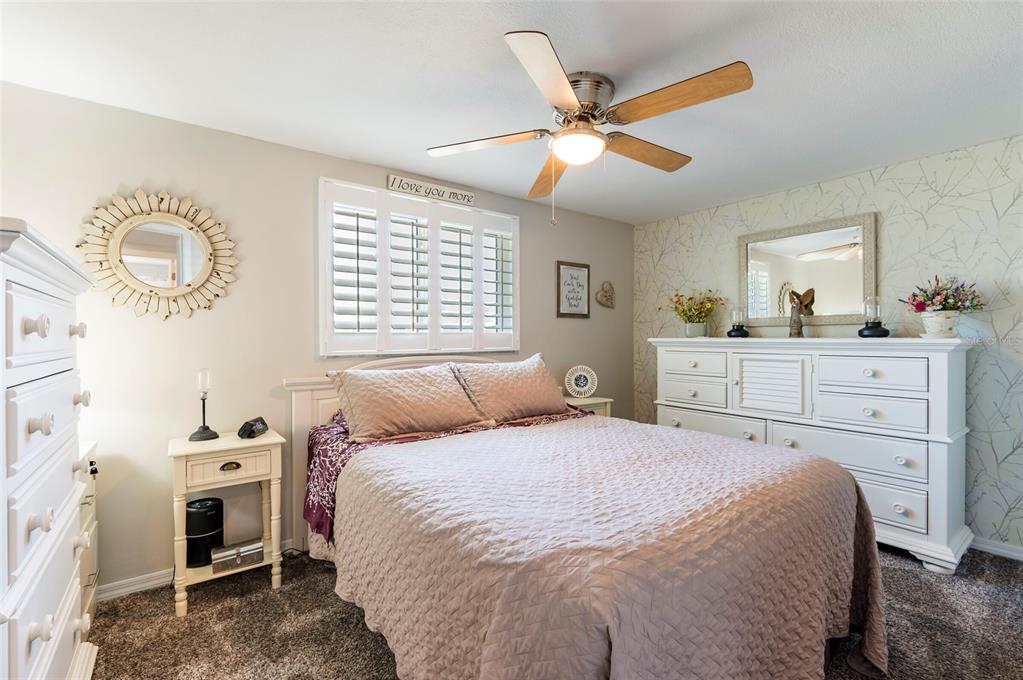 7804 Fox Hollow Drive Port Richey, FL 34668 - Photo 13 of 31 a bedroom with a bed and a chandelier