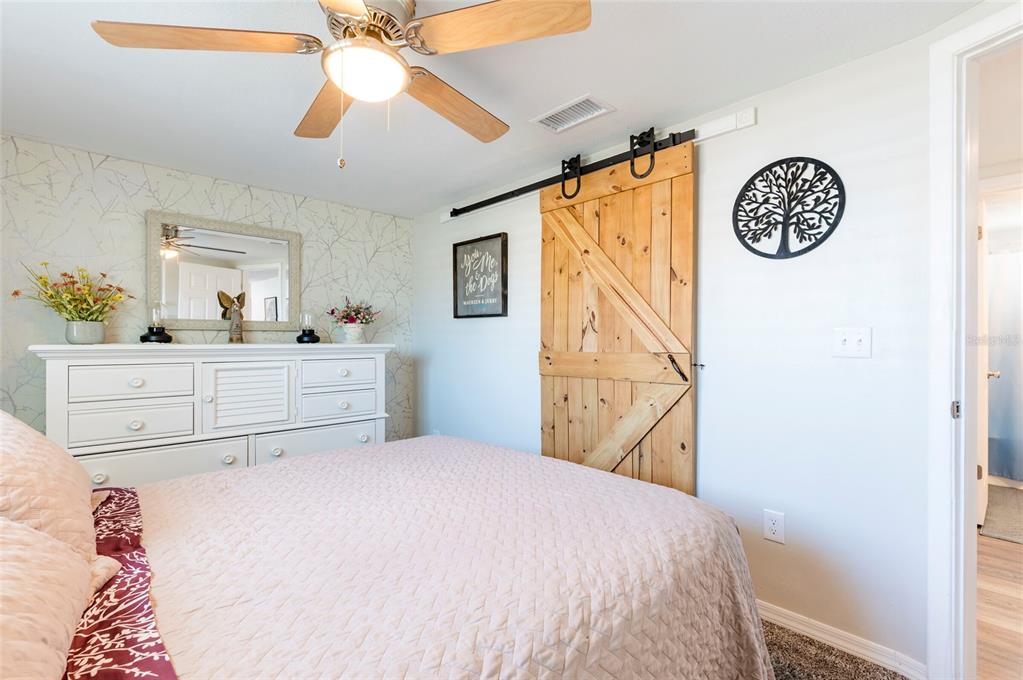 7804 Fox Hollow Drive Port Richey, FL 34668 - Photo 14 of 31 a bedroom with a bed and a chandelier