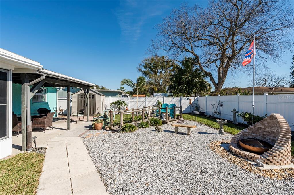7804 Fox Hollow Drive Port Richey, FL 34668 - Photo 30 of 31 a backyard of a house with barbeque oven table and chairs