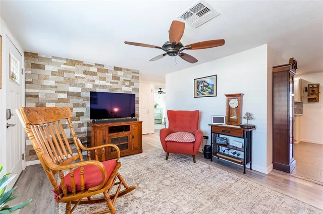 a living room with furniture a flat screen tv and a window