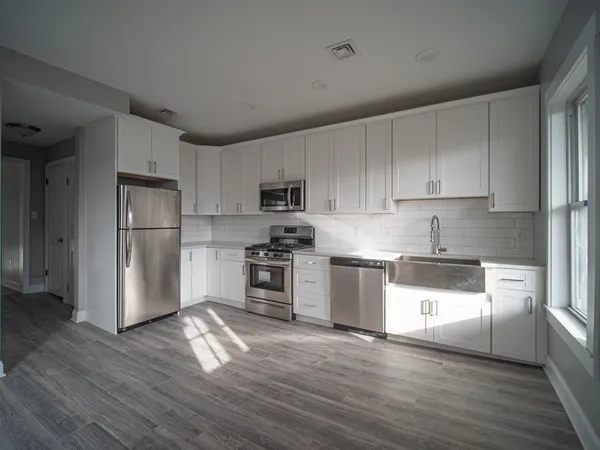 a kitchen with granite countertop white cabinets and stainless steel appliances