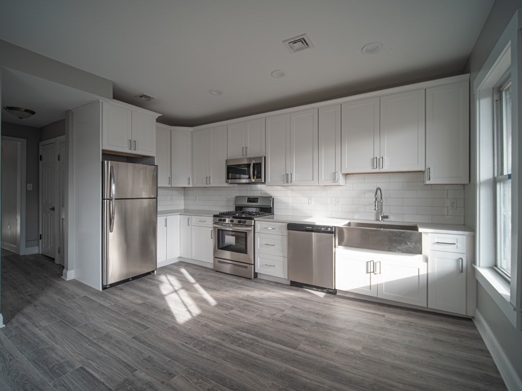 143 London Street, Unit 2 Boston, MA 02128 - Photo 1 of 9 a kitchen with granite countertop white cabinets and stainless steel appliances