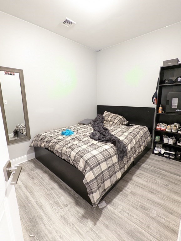 143 London Street, Unit 2 Boston, MA 02128 - Photo 6 of 9 a bedroom with a bed a mirror and dresser