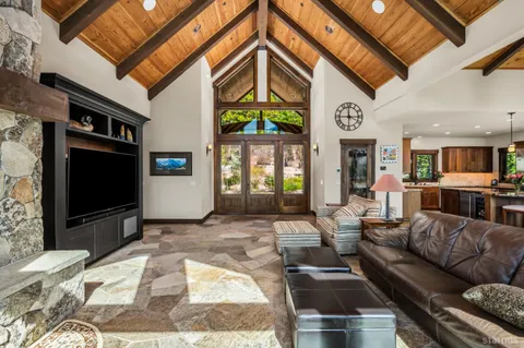 a view of kitchen with stainless steel appliances kitchen island granite countertop a refrigerator oven a stove a dining table and chairs with wooden floor