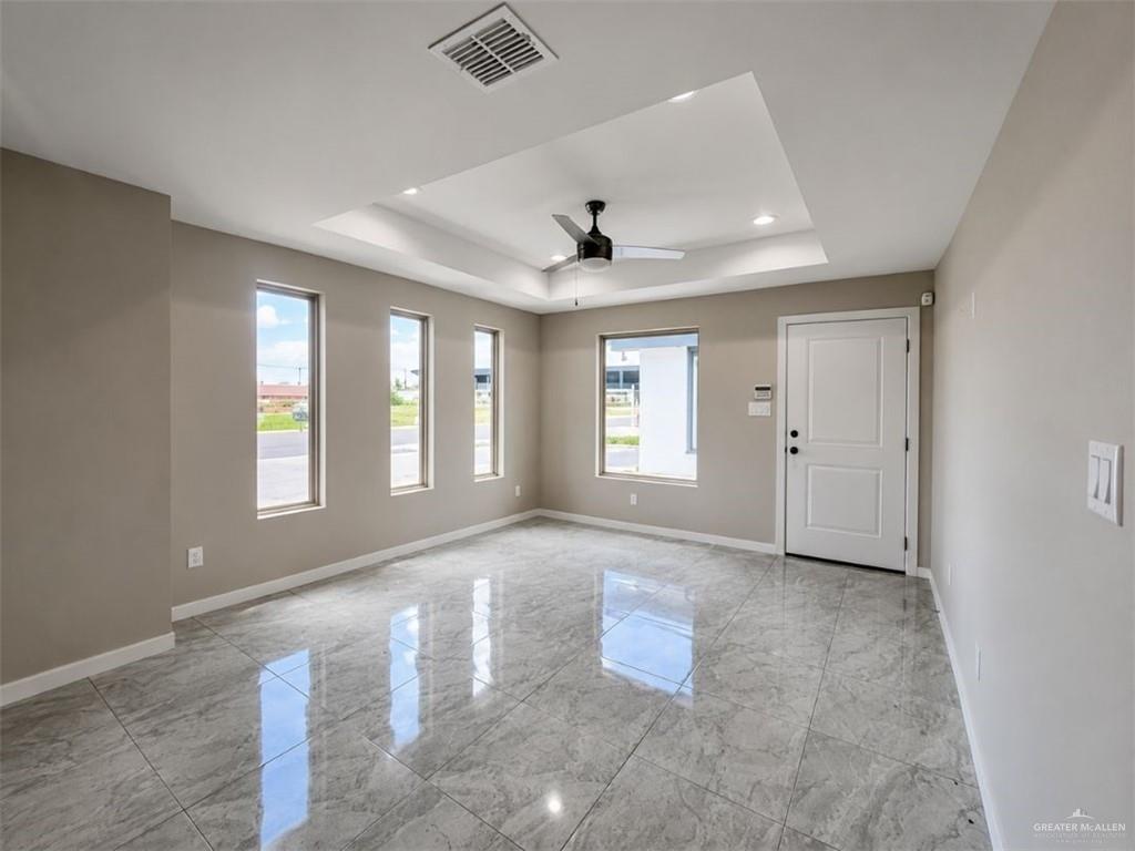 707 Palmer Road, Unit 3 Mission, TX 78573 - Photo 4 of 8 Spacious room featuring polished tile flooring, a tray ceiling with recessed lighting, and a modern ceiling fan