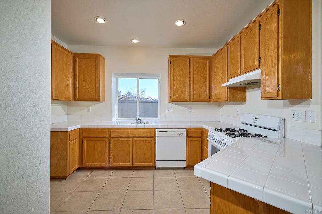 297 Diamante Way Oceanside, CA 92056 - Photo 7 of 28 a kitchen with stainless steel appliances granite countertop a sink and cabinets
