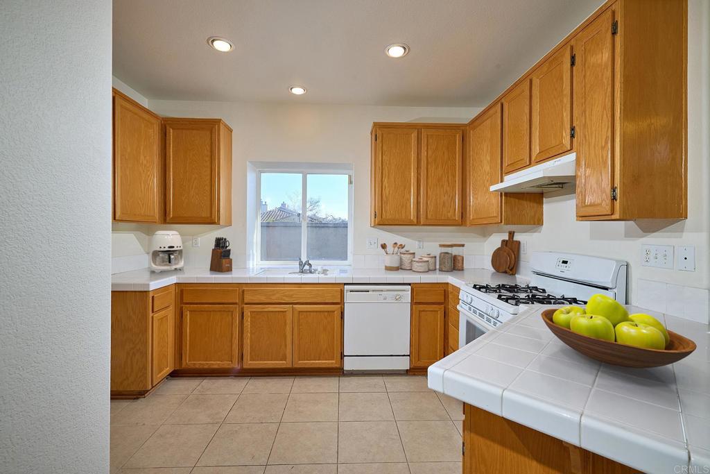 297 Diamante Way Oceanside, CA 92056 - Photo 8 of 28 a kitchen with a sink a stove and cabinets