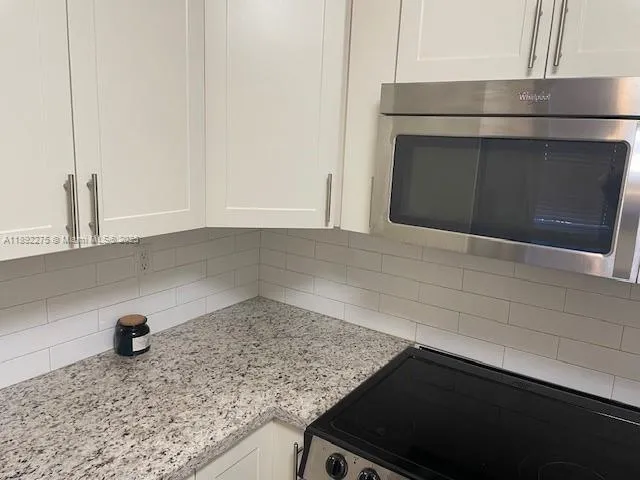 a kitchen with granite countertop a sink and a stove
