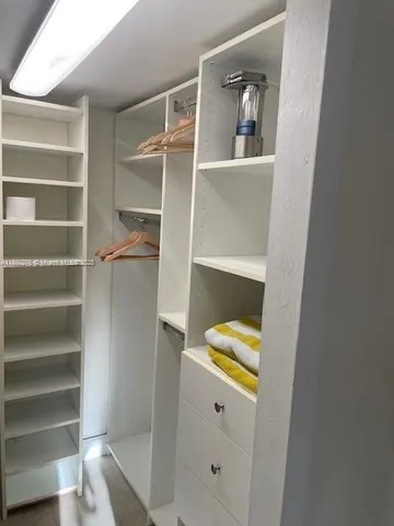 a view of walk in closet with empty racks