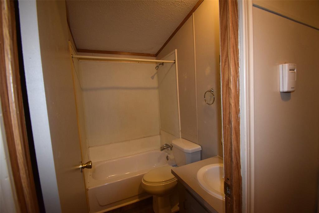 6000 Spring Creek Road, Unit 12 Malakoff, TX 75148 - Photo 7 of 10 a bathroom with a granite countertop sink toilet and shower