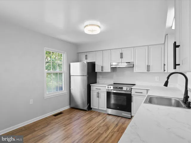 a kitchen with a stove a sink and a refrigerator