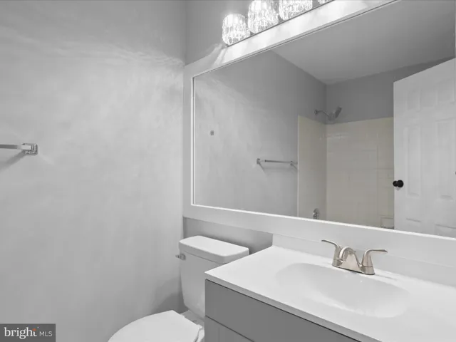 a bathroom with a sink a toilet and a mirror