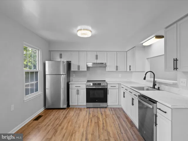 a kitchen with a sink cabinets stainless steel appliances and a window