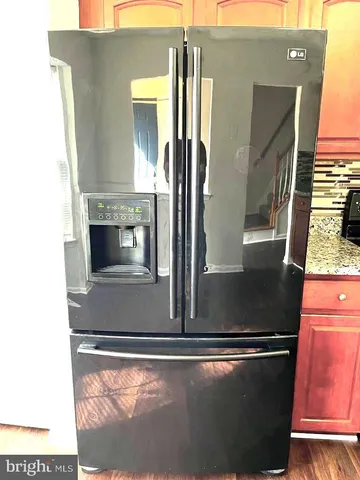 an empty room with wooden floor fireplace and windows