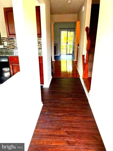 a view of a kitchen with wooden floor and a fireplace