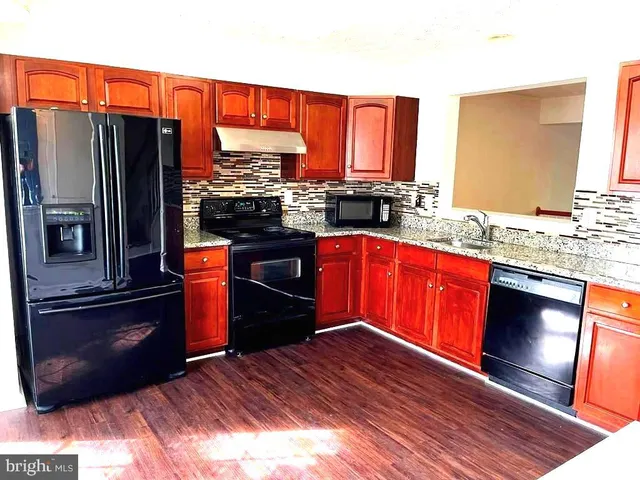 a stove top oven sitting inside of a kitchen