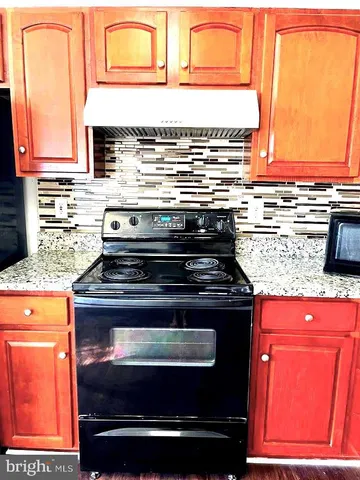 a bathroom with granite countertop a sink and a mirror