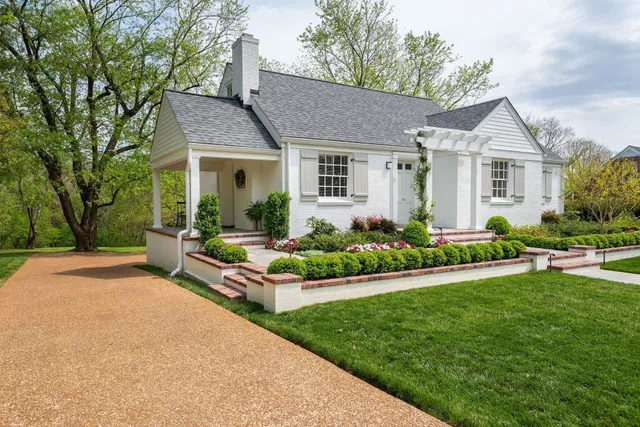 a front view of a house with a garden and plants