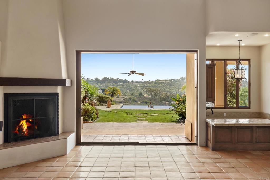 3435 Jasmine Crest Encinitas, CA 92024 - Photo 21 of 41 a view of an entryway with a fireplace and a floor to ceiling window