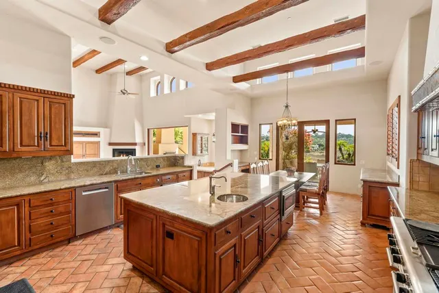 a kitchen with granite countertop a sink stove and cabinets