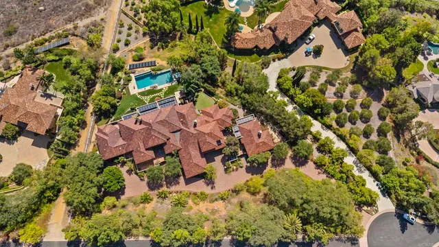 an aerial view of residential house with parking and yard
