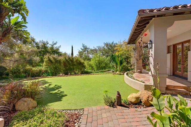 a living room with furniture a chandelier and kitchen view