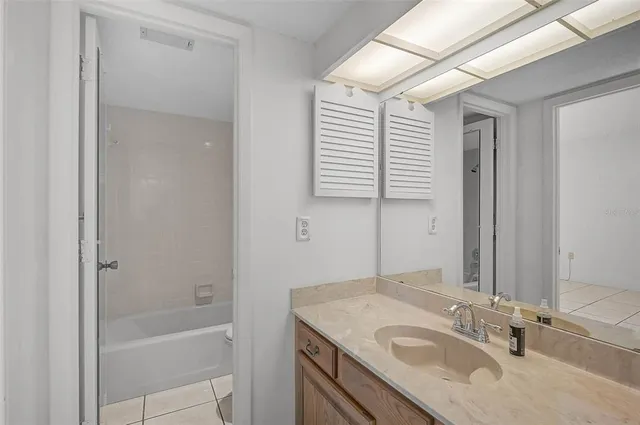a bathroom with a granite countertop sink mirror and a bathtub