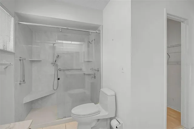 a bathroom with a granite countertop toilet a sink and shower