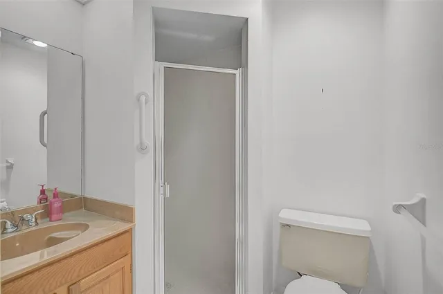 a bathroom with a granite countertop sink toilet and mirror