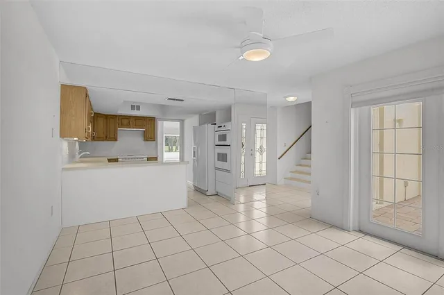 a view of kitchen with white cabinets and window