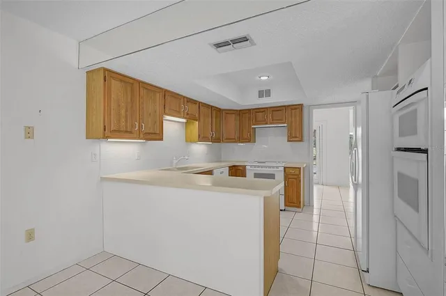 a kitchen with a sink a refrigerator and cabinets