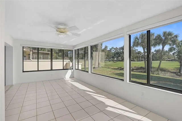 a view of an empty room with a floor to ceiling windows and a ceiling fan