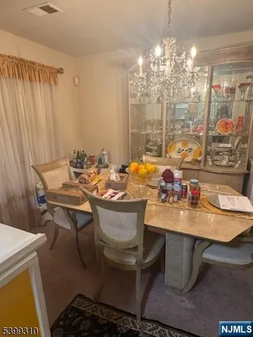 a room with a table chairs and a chandelier