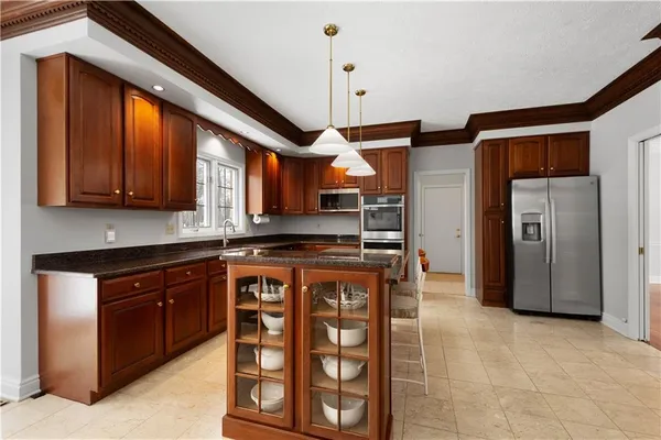 a kitchen with stainless steel appliances granite countertop a refrigerator and a stove top oven