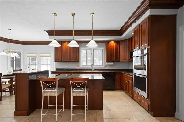 a kitchen with stainless steel appliances granite countertop a stove a sink and a refrigerator