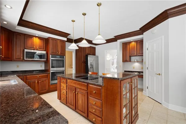 a kitchen with stainless steel appliances granite countertop a stove a sink and a refrigerator