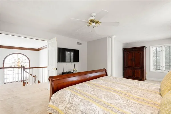 a bedroom with a bed and a chandelier