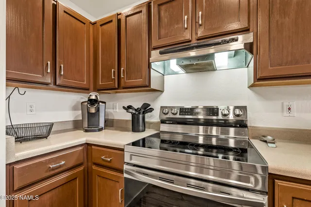 a kitchen with wooden cabinets and a stove top oven