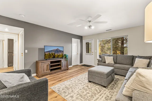a living room with furniture and a wooden floor