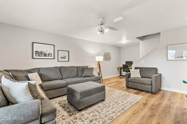 a living room with furniture and a wooden floor