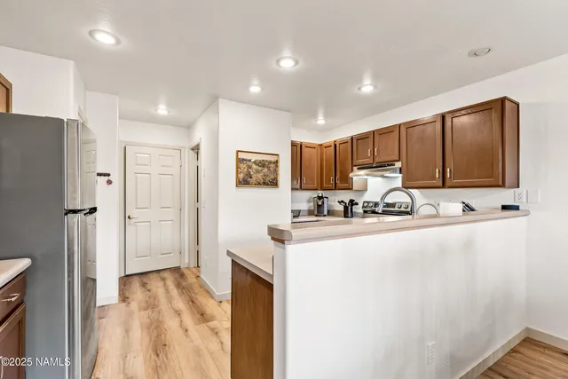 a kitchen with stainless steel appliances granite countertop a refrigerator and a sink