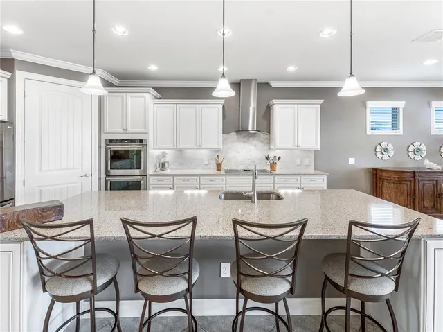 a living room with furniture kitchen view and a chandelier