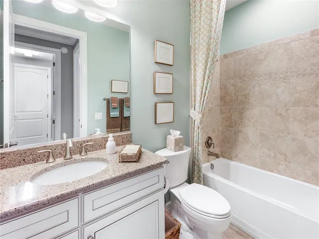 a bathroom with a double vanity sink a toilet and a shower