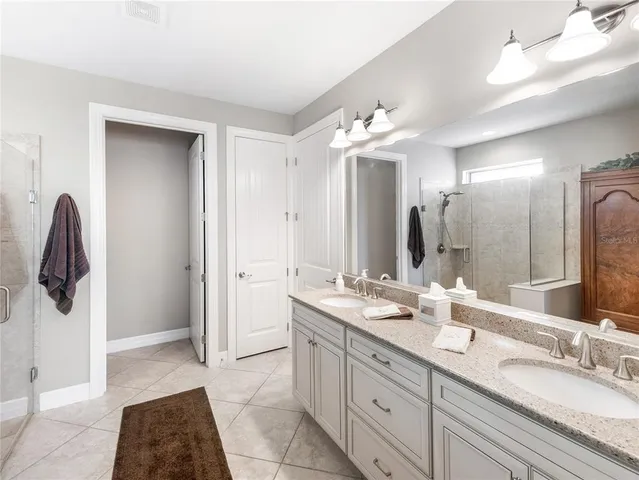 a kitchen with stainless steel appliances kitchen island granite countertop a stove a sink a refrigerator and white cabinets with wooden floor